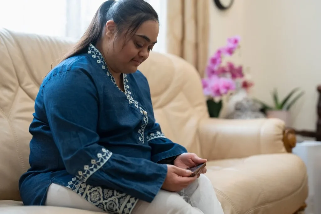 Disabled Indian woman with down syndrome using mobile phone