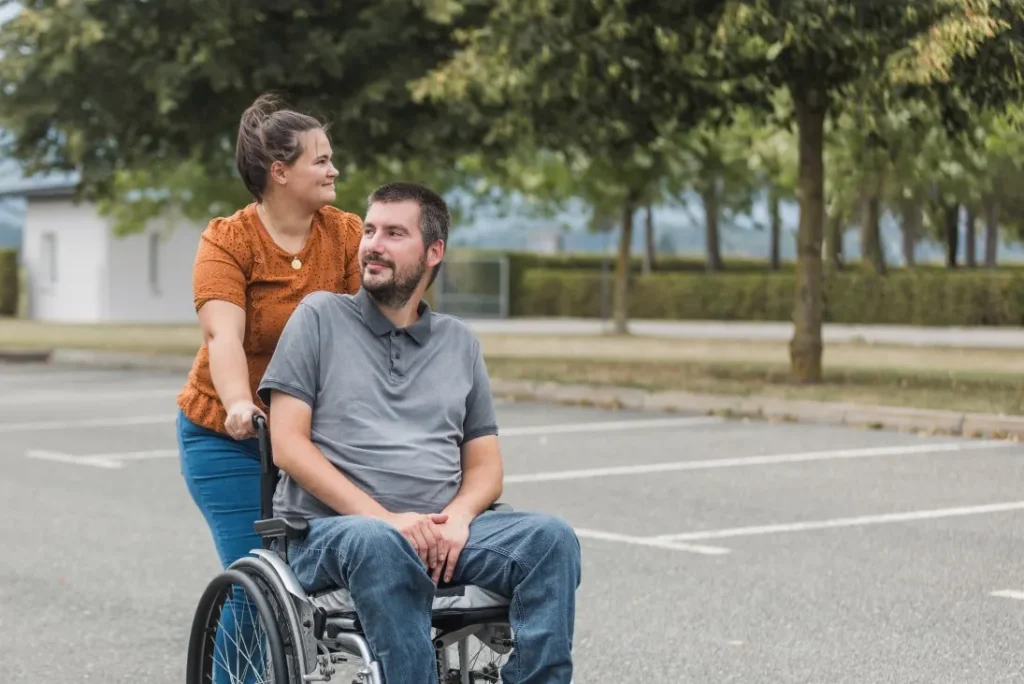 Support worker pushing disabled man in wheelchair