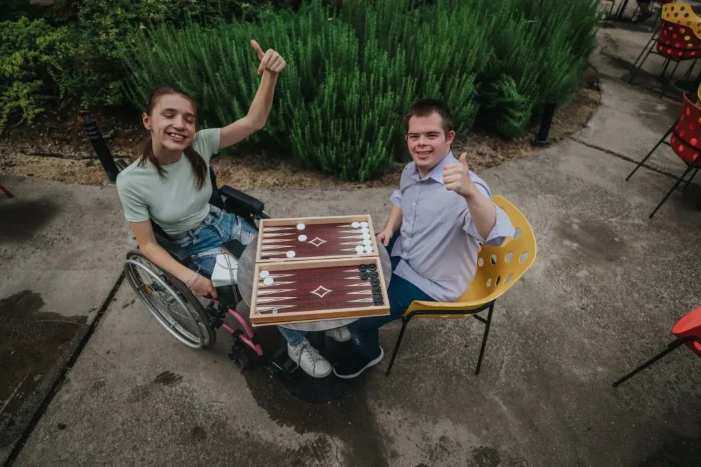 Two disabled friends playing a game outside